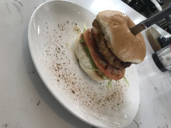 The Shrimp Burger at Chef Charles Bistreaux: a pan-seared shrimp patty with lettuce and tomato on a garlic-toasted bun