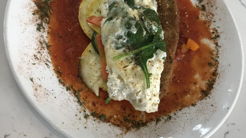 The veggie omelet at Chef Charles Bistreaux: an egg-white omelet over zucchini, squash, mushrooms, and spinach on tomato sauce